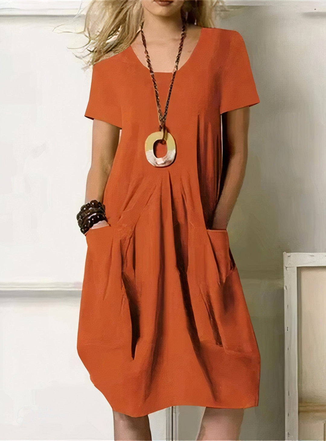 Woman in an easy cotton summer dress with a relaxed skim through the waist, dressed for a warm Sunday morning